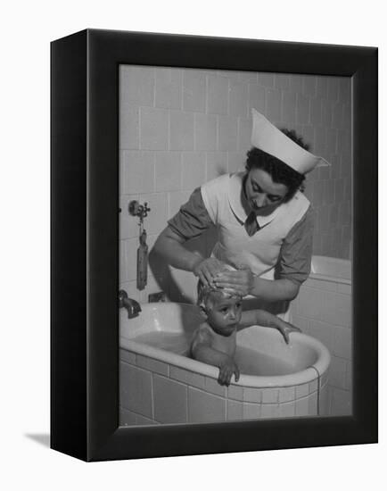 Woman Giving a Baby a Bath at a Nursery-null-Framed Premier Image Canvas