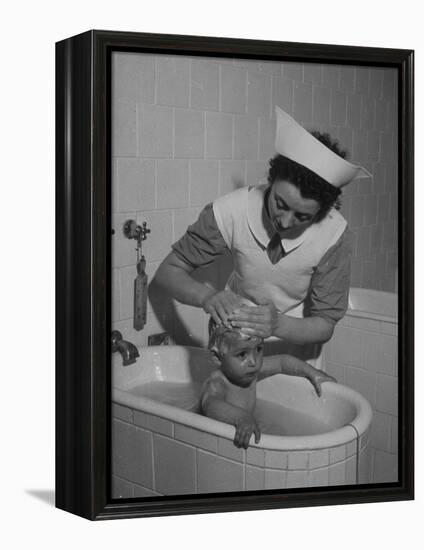 Woman Giving a Baby a Bath at a Nursery-null-Framed Premier Image Canvas