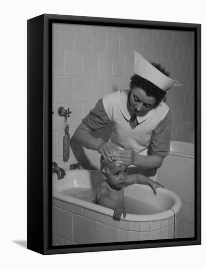 Woman Giving a Baby a Bath at a Nursery-null-Framed Premier Image Canvas