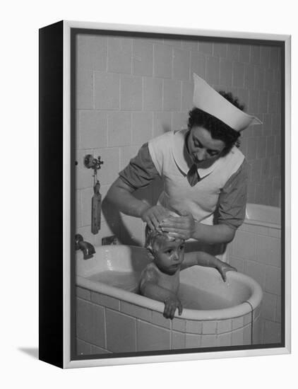 Woman Giving a Baby a Bath at a Nursery-null-Framed Premier Image Canvas