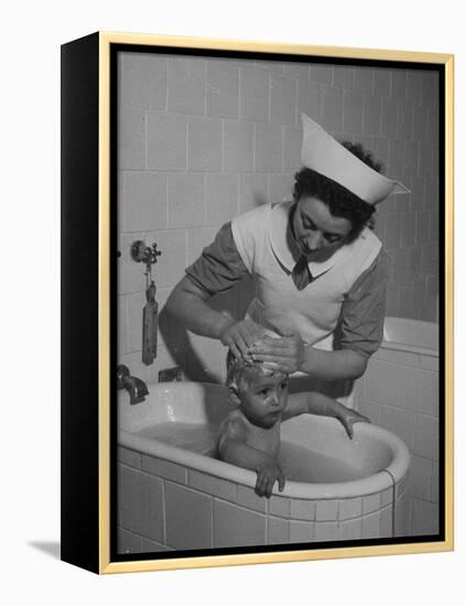 Woman Giving a Baby a Bath at a Nursery-null-Framed Premier Image Canvas