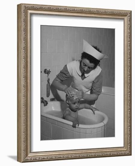 Woman Giving a Baby a Bath at a Nursery-null-Framed Photographic Print