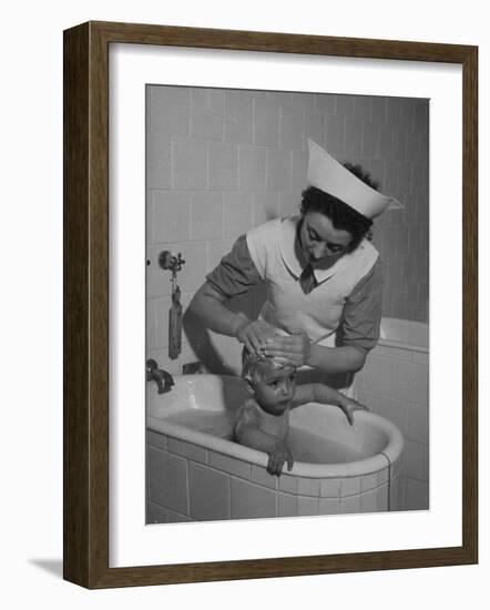 Woman Giving a Baby a Bath at a Nursery-null-Framed Photographic Print