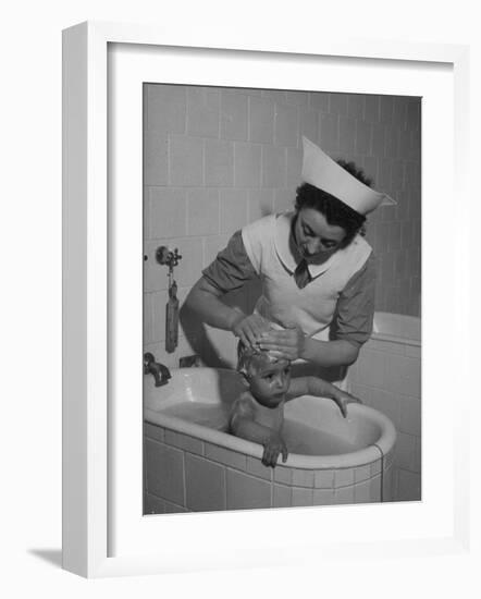 Woman Giving a Baby a Bath at a Nursery-null-Framed Photographic Print