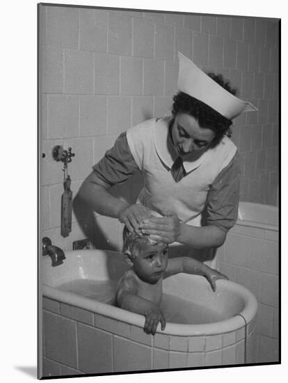 Woman Giving a Baby a Bath at a Nursery-null-Mounted Photographic Print