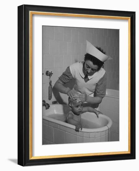 Woman Giving a Baby a Bath at a Nursery-null-Framed Photographic Print