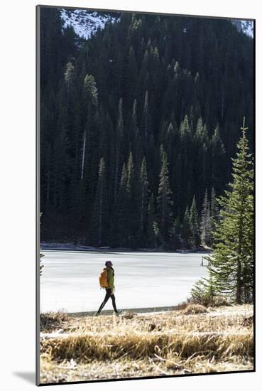 Woman Hiker Walks Alongside A Frozen Lake In The Olympic Mountain High Country During Winter In WA-Hannah Dewey-Mounted Photographic Print