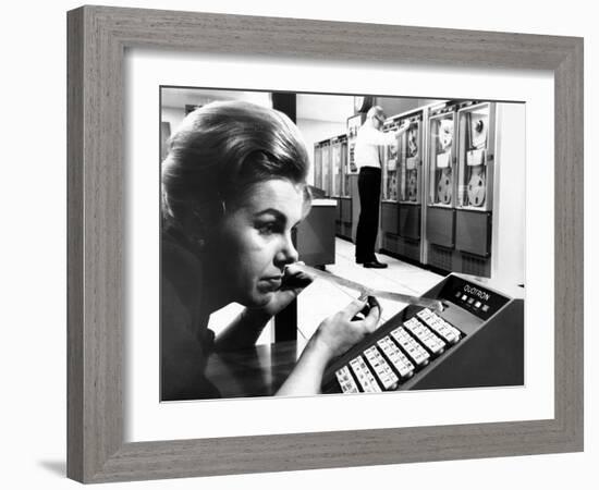 Woman Holds Tape with the Latest Stock Prices Printed by the Quotron II-null-Framed Photo