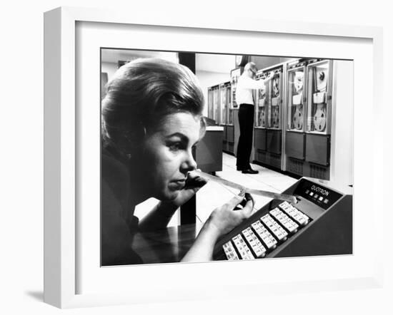 Woman Holds Tape with the Latest Stock Prices Printed by the Quotron II-null-Framed Photo