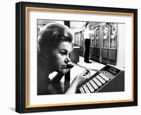 Woman Holds Tape with the Latest Stock Prices Printed by the Quotron II-null-Framed Photo