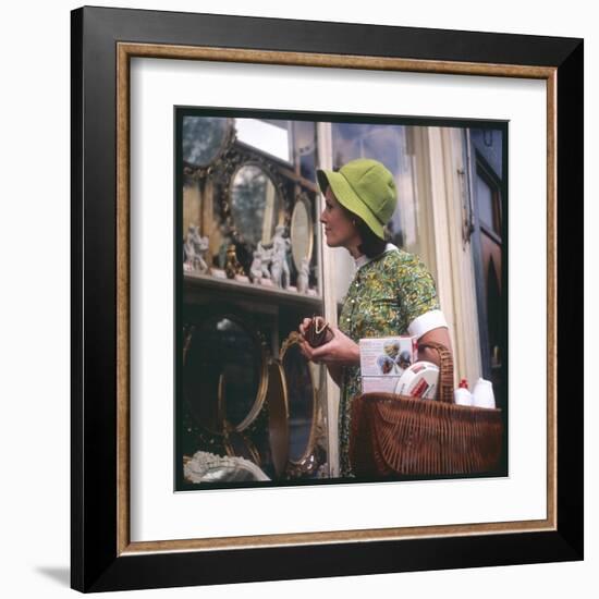 Woman in a Green Floppy Hat and Green Dress Browses in a Shop Selling Various Mirrors and Ornaments-null-Framed Art Print