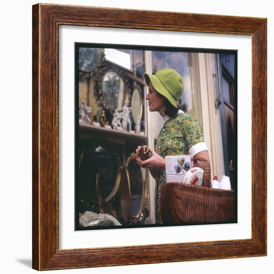 Woman in a Green Floppy Hat and Green Dress Browses in a Shop Selling Various Mirrors and Ornaments-null-Framed Premium Giclee Print