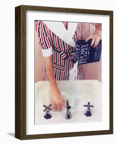 Woman in Red, White and Blue Robe Pouring Ivory Soap Flakes Into Bathroom Sink-Gjon Mili-Framed Photographic Print