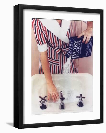 Woman in Red, White and Blue Robe Pouring Ivory Soap Flakes Into Bathroom Sink-Gjon Mili-Framed Photographic Print