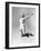 Woman Jumping into the Air with a Tennis Racket in Her Hand-null-Framed Photo