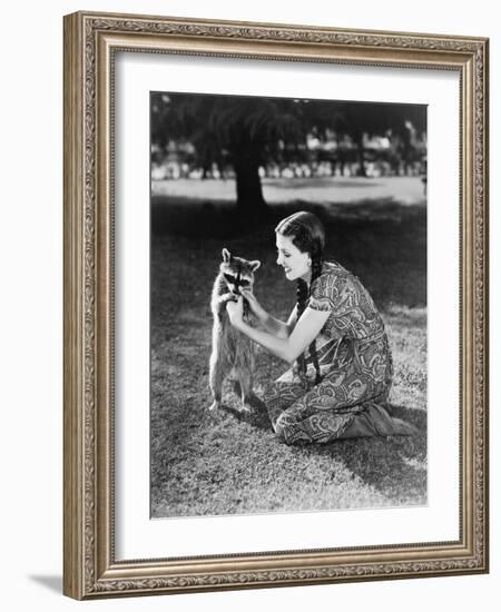 Woman Kneeling on the Lawn Playing with a Tame Raccoon-null-Framed Photo