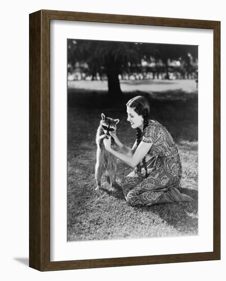 Woman Kneeling on the Lawn Playing with a Tame Raccoon-null-Framed Photo