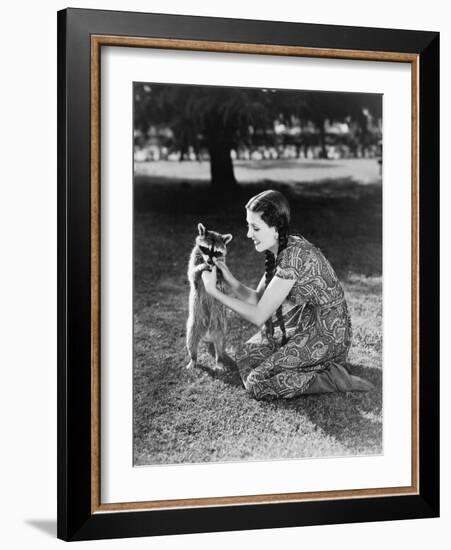 Woman Kneeling on the Lawn Playing with a Tame Raccoon-null-Framed Photo