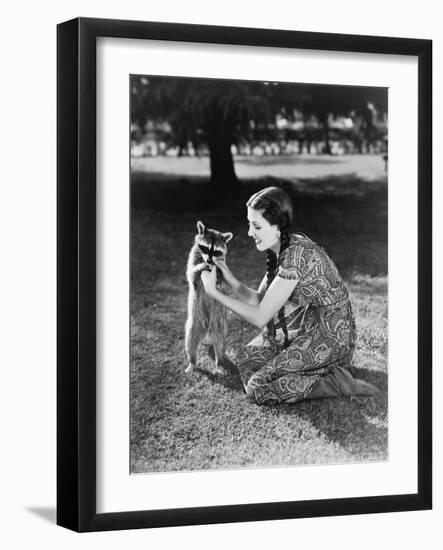 Woman Kneeling on the Lawn Playing with a Tame Raccoon-null-Framed Photo