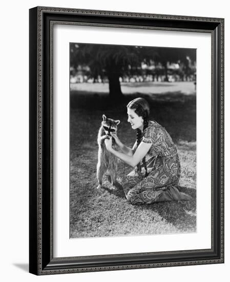 Woman Kneeling on the Lawn Playing with a Tame Raccoon-null-Framed Photo