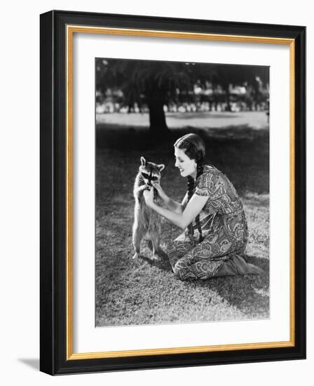 Woman Kneeling on the Lawn Playing with a Tame Raccoon-null-Framed Photo