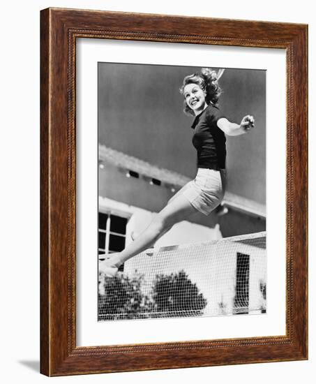 Woman Leaping over a Tennis Net-null-Framed Photo