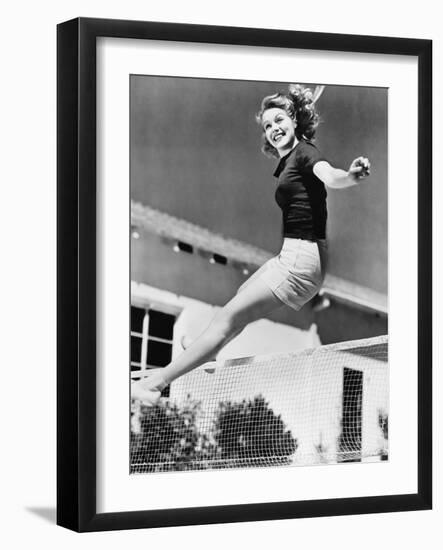 Woman Leaping over a Tennis Net-null-Framed Photo