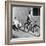 Woman on a Bicycle Pulling a Grown Man on a Toy Tricycle-null-Framed Photo