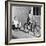 Woman on a Bicycle Pulling a Grown Man on a Toy Tricycle-null-Framed Photo