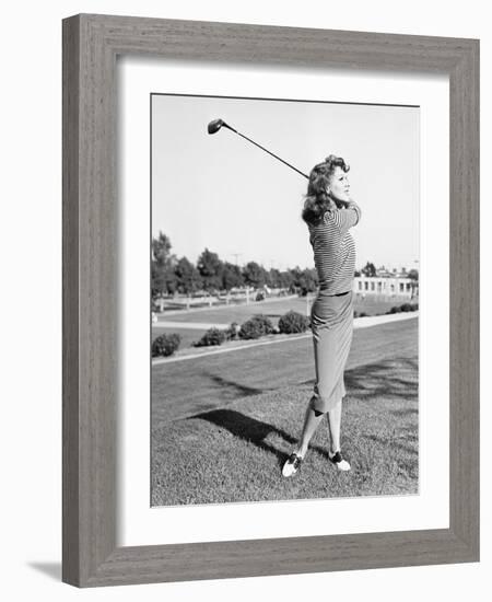 Woman on the Driving Range Swinging a Golf Club-null-Framed Photo