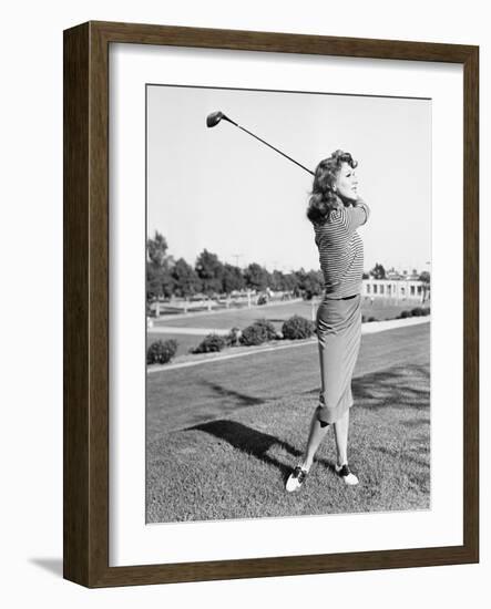Woman on the Driving Range Swinging a Golf Club-null-Framed Photo