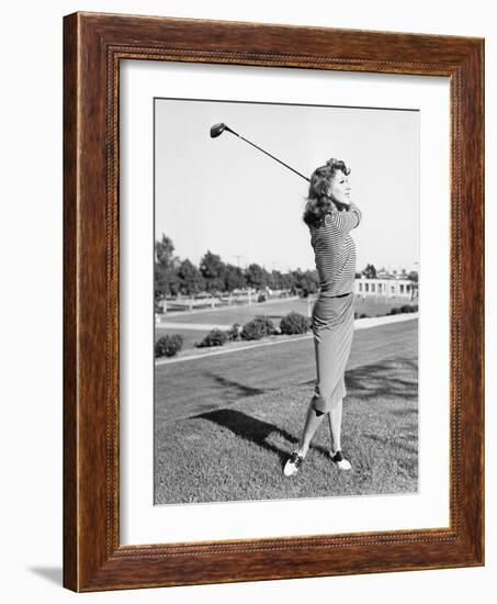 Woman on the Driving Range Swinging a Golf Club-null-Framed Photo