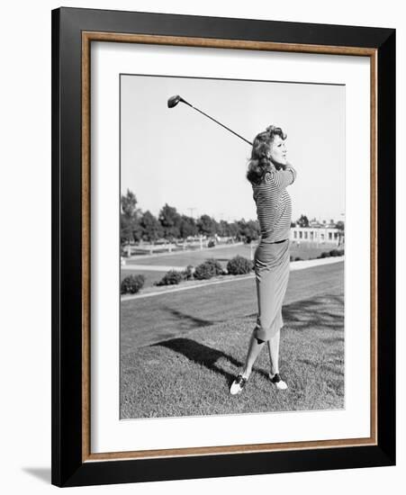 Woman on the Driving Range Swinging a Golf Club-null-Framed Photo