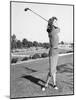 Woman on the Driving Range Swinging a Golf Club-null-Mounted Photo