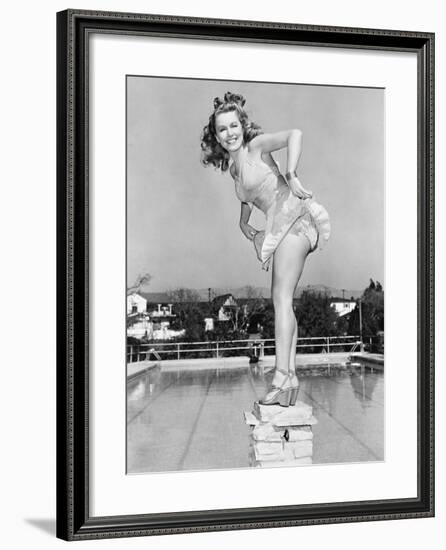 Woman Posing on Top of a Pillar Next to a Swimming Pool-null-Framed Photo