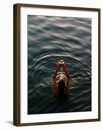 Woman Pouring Water During Morning Puja on Ganges, Varanasi, India-Anthony Plummer-Framed Photographic Print
