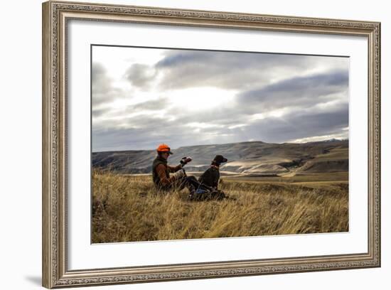 Woman Pours A Cup Of Tea From Her Thermos While She And Her Hunting Dog Take A Break On A Hillside-Hannah Dewey-Framed Photographic Print