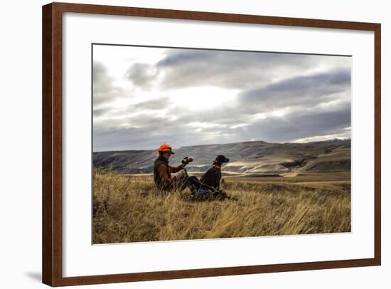 Woman Pours A Cup Of Tea From Her Thermos While She And Her Hunting Dog Take A Break On A Hillside-Hannah Dewey-Framed Photographic Print
