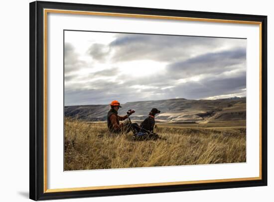 Woman Pours A Cup Of Tea From Her Thermos While She And Her Hunting Dog Take A Break On A Hillside-Hannah Dewey-Framed Photographic Print