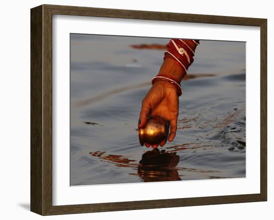 Woman Praying on the Banks of the River Ganges Fills Water into a Copper Vessel for a Ritual-null-Framed Photographic Print
