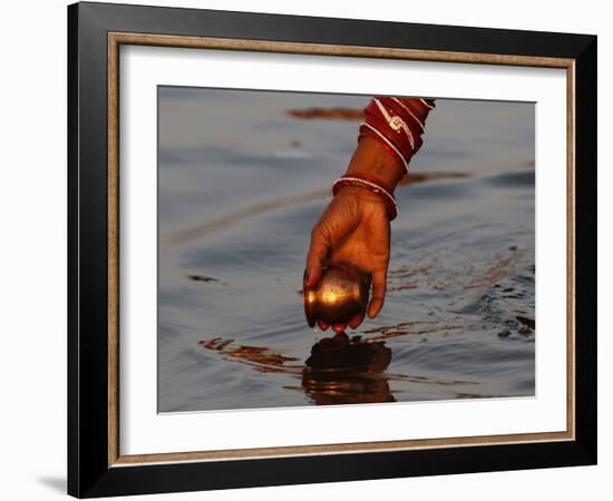 Woman Praying on the Banks of the River Ganges Fills Water into a Copper Vessel for a Ritual-null-Framed Photographic Print