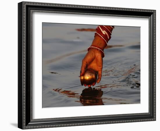 Woman Praying on the Banks of the River Ganges Fills Water into a Copper Vessel for a Ritual-null-Framed Photographic Print