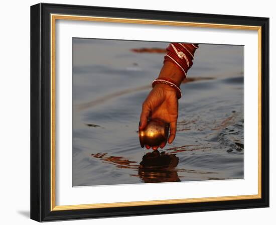 Woman Praying on the Banks of the River Ganges Fills Water into a Copper Vessel for a Ritual-null-Framed Photographic Print