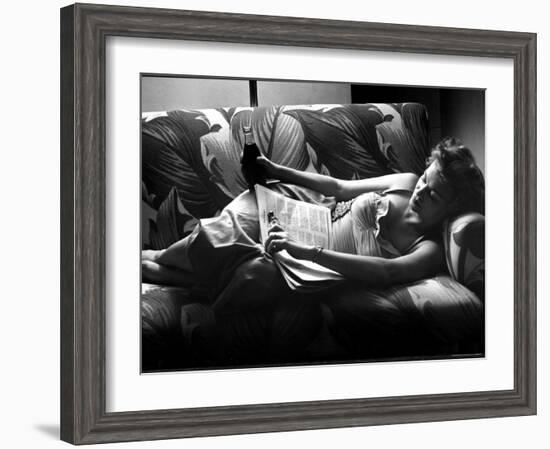 Woman Relaxing on Sofa, Reading and Drinking a Coke-Nina Leen-Framed Photographic Print