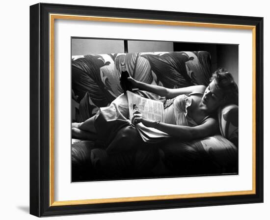 Woman Relaxing on Sofa, Reading and Drinking a Coke-Nina Leen-Framed Photographic Print