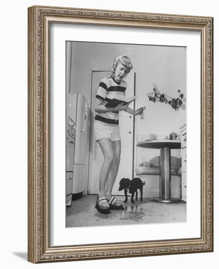 Woman Scrubbing Kitchen Floor with Brushes Attached to Her Feet-Allan Grant-Framed Photographic Print