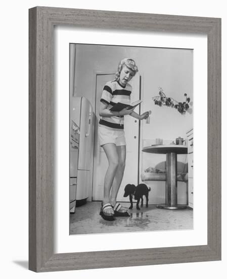 Woman Scrubbing Kitchen Floor with Brushes Attached to Her Feet-Allan Grant-Framed Photographic Print