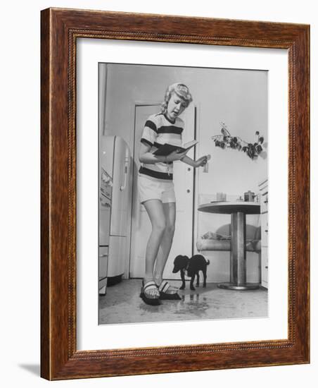 Woman Scrubbing Kitchen Floor with Brushes Attached to Her Feet-Allan Grant-Framed Photographic Print