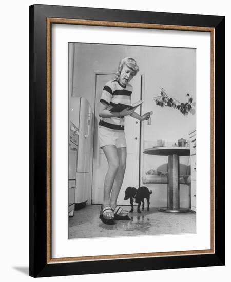 Woman Scrubbing Kitchen Floor with Brushes Attached to Her Feet-Allan Grant-Framed Photographic Print