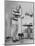 Woman Scrubbing Kitchen Floor with Brushes Attached to Her Feet-Allan Grant-Mounted Photographic Print